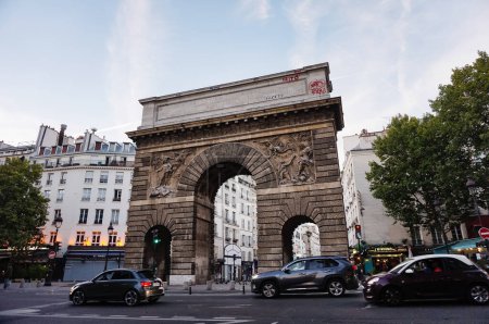 Foto de París, Francia - Sept. 2022 - Parte superior, con bajorrelieves, de la "Porte Saint-Martin" (Puerta de San Martín), un arco triunfal construido en estilo clásico en el siglo XVII, en honor al rey Luis XIV - Imagen libre de derechos