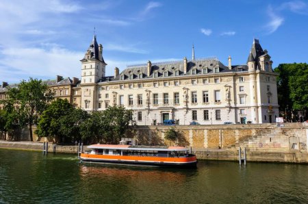 Photo for Paris, France -June 2019- A cruise barge in front of the Criminal Court of Paris, housed in a wing of the Palais de la Cite, a former royal palace built by the River Seine on the island Ile de la Cite - Royalty Free Image