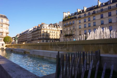 Photo for Paris, France - April 2021 - Fountain of the City Hall Square, below a row of elegant Haussmann-style town buildings on Rue Rivoli, in the 4th arrondissement, one of the capital's poshest streets - Royalty Free Image