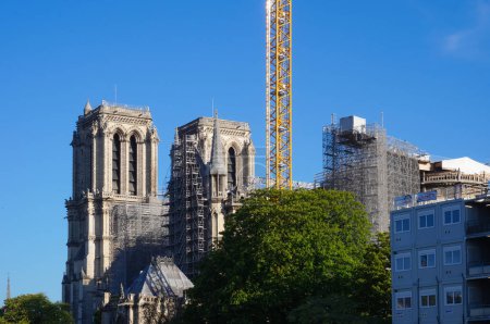 Foto de París, Francia - Abril 2021 - Una grúa torre de gran altura sobresale del enorme andamio instalado en el sitio de reconstrucción de la Catedral de Notre Dame, que fue severamente dañado después del incendio de 2019 - Imagen libre de derechos
