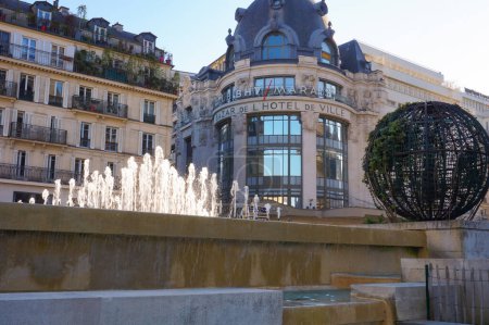 Foto de París, Francia - Abril 2021 - Frente a los chorros de agua de la plaza del Ayuntamiento, el edificio abovedado del siglo XIX del BHV Marais (Bazar de l 'Hotel de Ville), un centro de estilo de vida en el distrito 4. - Imagen libre de derechos
