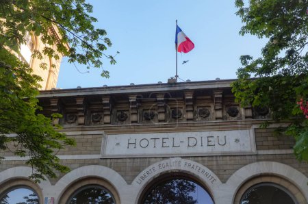 Foto de París, Francia - abril de 2021 - Frontón coronada con una bandera francesa del Hotel-Dieu, un hospital público histórico construido en el siglo XIX en el Parvis de la Catedral de Notre-Dame, actualmente dirigido por la APHP - Imagen libre de derechos