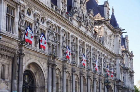 Photo for Paris, France - April 2021 - Late 19th century facade, adorned with flags of France, of the Neo-Renaissance palace of the City Hall of Paris ; the monument is Europe's largest municipal building - Royalty Free Image