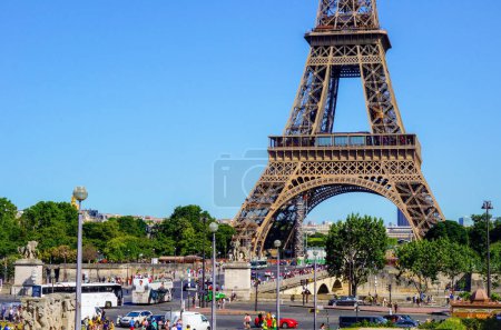 Photo for Paris, France - June 2019 - The crowded arch bridge Pont d'Ina, full of tourists, over the River Seine at the foot of the world-famous Eiffel Tower, the highly touristy symbol of the French capital - Royalty Free Image