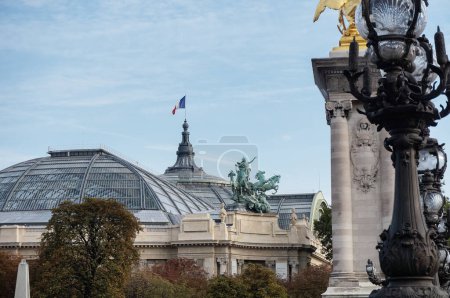 Foto de Canopy de vidrio, rematado con una bandera francesa, del "Grand Palais" (Gran Palacio), que fue construido para la Feria Mundial de 1900 en el octavo arrondissement de París, en Francia, visto desde el puente Alexandre-III - Imagen libre de derechos