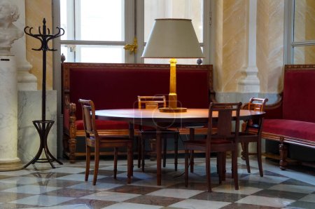 Téléchargez les photos : Paris, France - Novembre 2022 - Une table ronde surmontée d'une lampe avec abat-jour, chaises et canapés rouges dans un salon à l'intérieur du Palais Bourbon, siège de l'Assemblée nationale, chambre basse du Parlement français - en image libre de droit
