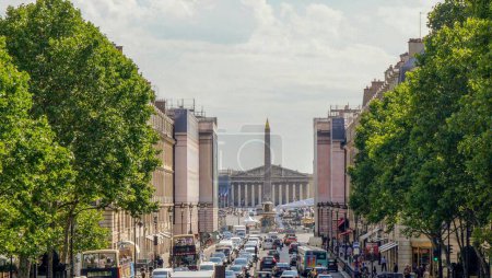 Téléchargez les photos : Paris, France - Juillet 2019 - Le trafic de la rue Royale bordée d'arbres dans la perspective de l'obélisque de la place de la Concorde et du palais Bourbon, siège de l'Assemblée nationale - en image libre de droit