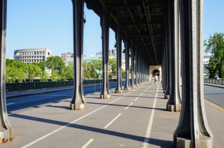 Photo for Paris, France - June 2019 - Perspective of the cycle lane and riveted metal pillars of the iconic double-decker bridge Pont de Bir-Hakeim, in the touristy 16th arrondissement of the French capital - Royalty Free Image