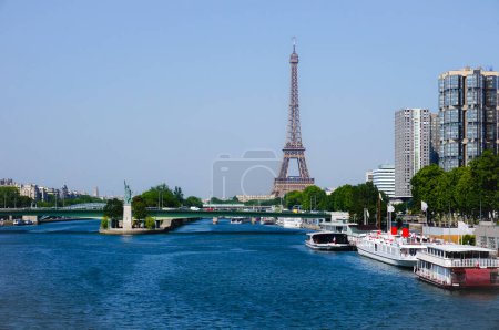 Téléchargez les photos : Paris, France - Juin 2019 - La Seine coulant sous le pont Pont de Grenelle, après le Pont de Bir-Hakeim, les gratte-ciel du Front de Seine, le port fluvial de Javel avec barges et la Tour Eiffel - en image libre de droit