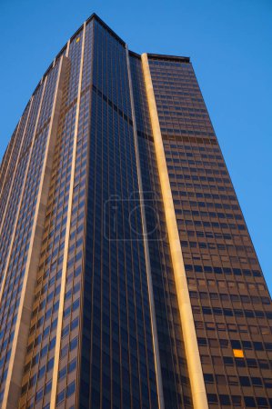 Photo for Paris, France - April 2021 - Low angle view at sunset of the 210-meter high Montparnasse Tower, a glass skyscraper and a business centre built in the 1970s in the capital's 15th arrondissement - Royalty Free Image
