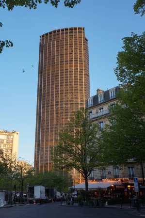 Téléchargez les photos : Paris, France - Avril 2021 - La Tour Montparnasse, gratte-ciel vitré et centre d'affaires construit dans les années 1970 dans le 15ème arrondissement de la capitale, vu au coucher du soleil depuis le boulevard Edgard Quinet - en image libre de droit