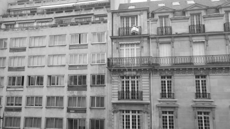 Foto de París, Francia - Julio 2019 - Foto en blanco y negro - Contraste entre un moderno y un edificio de apartamentos de estilo Haussmann construido uno al lado del otro, en Pump Street (Rue de la Pompe), distrito 16 - Imagen libre de derechos