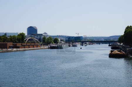 Téléchargez les photos : Paris, France - Juin 2019 - Bateaux et péniches fluviaux, dont certains transportant du sable et des bateaux de croisière, mouillant le long des quais sur la Seine, dans le port de Javel, vus du pont Mirabeau - en image libre de droit