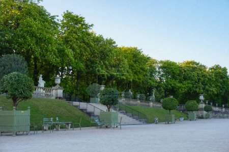 Téléchargez les photos : Paris, France - Avril 2021 - Un talus recouvert de pelouse, avec un escalier extérieur, et des arbres taillés dans les Jardins du Luxembourg, le parc du Sénat français, dans le 6ème arrondissement - en image libre de droit