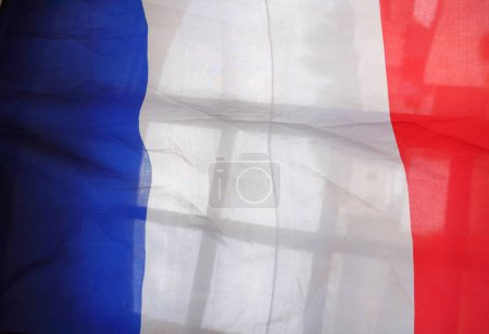 Téléchargez les photos : Un tissu fin aux couleurs nationales du drapeau bleu, blanc et rouge de France, réalisé dans un matériau légèrement transparent ondulant dans le vent - en image libre de droit