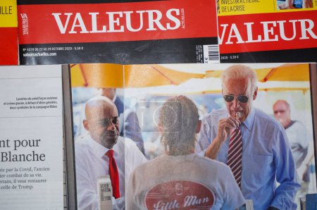 Foto de Occitanie, Francia - Oct. 2020 - El retrato de Joe Biden en una revista conservadora francesa, disfrutando de un cono de helado y usando gafas de sol durante su campaña, mientras el candidato se postulaba para presidente - Imagen libre de derechos
