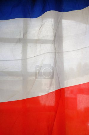 Foto de Una fina pieza de tela en los colores nacionales de la bandera azul, blanca y roja de Francia, hecha en un material ligeramente transparente ondulado en el viento - Imagen libre de derechos