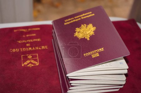 Foto de Toulouse, Francia - Dic. 2020 - Una pila de varios documentos de identificación, incluyendo pasaportes de la República Francesa, que es miembro de la Unión Europea, y libros oficiales de registro familiar - Imagen libre de derechos
