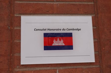 Photo for Toulouse, France - Dec. 2020 - French-written plate on the brick wall of the Honorary Consulate of the Kingdom of Cambodia, displaying the Khmer flag, which features the temple of Angkor Wat - Royalty Free Image