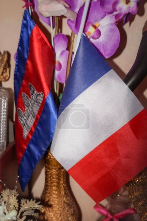 Foto de Banderas de Francia y Camboya reunidas en una maceta, como signo de amistad entre los dos países, y también simbolizando la doble identidad de los ciudadanos de la diáspora jemer en Francia - Imagen libre de derechos