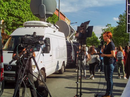 Photo for Albi, France -May 4, 2017- Television crew with a female journalist's live report filmed by the camera operator of a news channel providing the media coverage of Emmanuel Macron's last election rally - Royalty Free Image