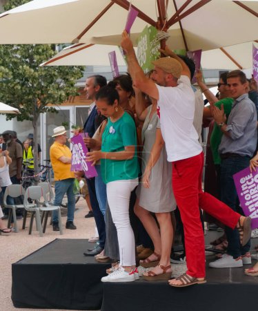 Foto de Toulouse, Francia - 25 de junio de 2020 - Alegre compañero de fórmula de Archipel Citoyen salta al escenario, agitando las señales electorales y rodeando a su candidato principal, Antoine Maurice, en una campaña al aire libre - Imagen libre de derechos