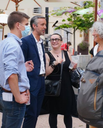 Téléchargez les photos : Toulouse, France - 25 juin 2020 - Antoine Maurice, candidat écologiste d'Archipel Citoyen à la mairie de Toulouse, souriant, s'entretient avec des sympathisantes et un jeune membre masqué de son équipe de campagne - en image libre de droit