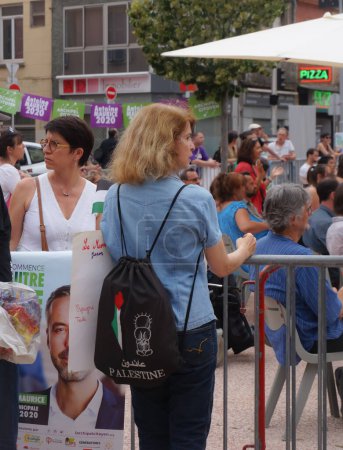 Foto de Toulouse, Francia - 25 de junio de 2020 - Un activista pro-palestino se coloca junto a un cartel electoral de Antoine Maurice, candidato de Archipel Citoyen para alcalde de Toulouse, en un mitin de campaña que realiza - Imagen libre de derechos