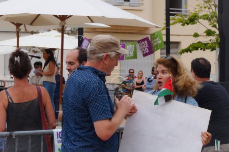 Foto de Toulouse, Francia - 25 de junio de 2020 - Un activista antisionista con bandera de Palestina y un letrero que dice "Libertad de expresión para BDS", conversa con un hombre en una reunión electoral del ecologista Antoine Maurice - Imagen libre de derechos