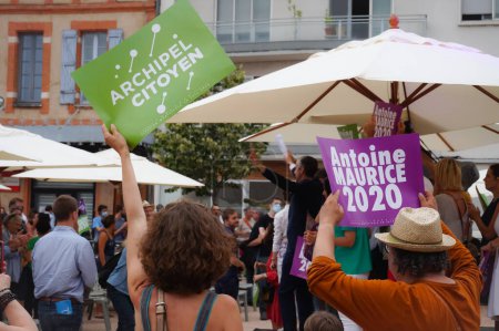 Foto de Toulouse, Francia - 25 de junio de 2020 - Activistas entusiastas saludan alegremente las señales electorales mientras Antoine Maurice, candidato ecologista de Archipel Citoyen, saluda a sus partidarios en una manifestación al aire libre - Imagen libre de derechos