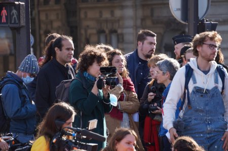 Foto de París, Francia - Nov. 2022 - Periodistas de televisión reunidos en torno a la miembro de extrema izquierda de la Asamblea Nacional Sandrine Rousseau (NUPES) para entrevistarla, durante una protesta ecologista frente al Palacio de Borbón - Imagen libre de derechos