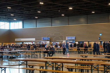 Foto de Reims, Francia - 5 de febrero de 2022 - Mesas de picnic y puestos en una sala del centro de exposiciones, para la reunión de los partidarios nacionales de Rassemblement, en la Convención Presidencial de Marine Le Pen - Imagen libre de derechos