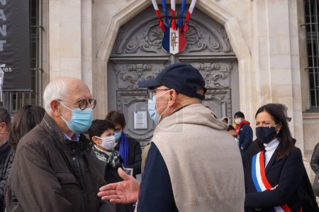 Photo for Troyes, France - Oct. 18, 2020 - Shocked elderly men talk about the beheading of Samuel Paty, at the homage to this teacher, beheaded by an jihadist for showing Charlie Hebdo's cartoons of Mohammed - Royalty Free Image