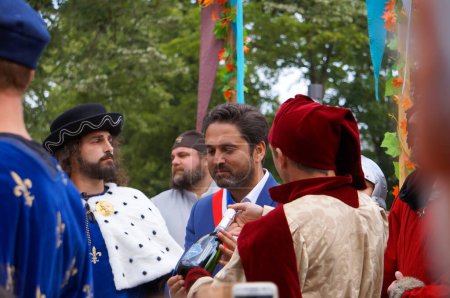 Photo for Reims, France - May 28, 2022 - King Charles VII of France is offered a bottle of Champagne by Arnaud Robinet, mayor of Reims, at the 2022 "Fetes Johanniques", which celebrate Joan of Arc's tale - Royalty Free Image