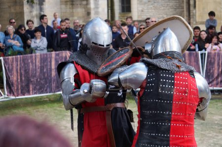 Foto de Reims, Francia - 29 de mayo de 2022 - Combate cercano entre actores en armadura de batalla, durante una reconstitución de un duelo de caballeros medievales, en las "Johanniques Fetes", que celebran la fiesta de Juana de Arco. - Imagen libre de derechos