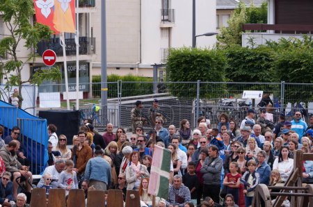Téléchargez les photos : Reims, France - Mai 2022 - En arrière-plan, des soldats de l'armée française équipés de fusils d'assaut et des policiers patrouillent alors que le public assiste à un spectacle, lors d'un festival - en image libre de droit