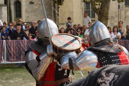 Téléchargez les photos : Reims, France - Mai 2022 - Photo floue mettant en scène deux chevaliers en combat rapproché, lors d'un duel d'épée en armure et en chaîne, aux "Fetes johanniques" de 2022, qui célèbrent le conte de Jeanne d'Arc - en image libre de droit