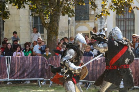 Téléchargez les photos : Reims, France - Mai 2022 - Photo floue mettant en scène deux chevaliers en armure, s'attaquant l'un l'autre avec une épée et une hache, lors des "Fetes johanniques" de 2022, qui célèbrent le conte de Jeanne d'Arc - en image libre de droit