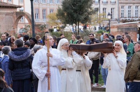 Foto de Toulouse, Francia - Marzo 2023 - Un grupo de monjas católicas llevan una cruz cristiana de madera, mientras que un joven monje sostiene una vela, en una procesión religiosa en celebración de la Anunciación, en el Día de la Señora. - Imagen libre de derechos