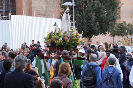 Téléchargez les photos : Toulouse, France - Mars 2023 - Une statue fleurie de Marie, la Vierge, est portée par les croyants catholiques noirs parmi la foule, dans une procession religieuse qui célèbre l'Annonciation, le jour de la fête des dames - en image libre de droit