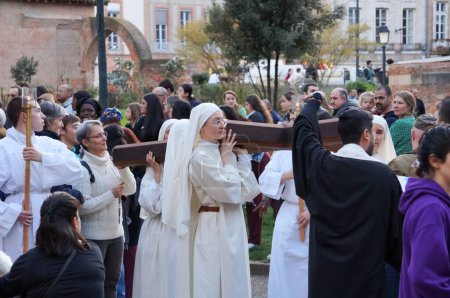 Foto de Toulouse, Francia - Marzo 2023 - Un grupo de monjas católicas llevan una cruz cristiana de madera, mientras que un joven monje sostiene una vela, en una procesión religiosa en celebración de la Anunciación, en el Día de la Señora. - Imagen libre de derechos