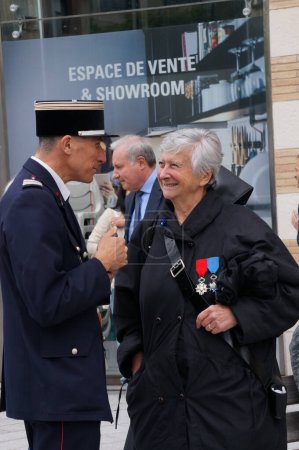 Foto de Toulouse, Francia - Abril 2023 - Una abanderada veterana galardonada con la Legión de Honor y la Orden Nacional del Mérito, conversa con un teniente coronel de bomberos después de una conmemoración - Imagen libre de derechos
