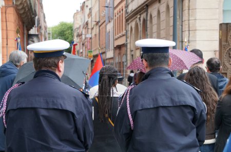 Foto de Toulouse, Francia - Abril 2023 - Por detrás, dos oficiales de policía, con uniformes de vestir con fourragere y kepi blanco, asisten a la conmemoración oficial del genocidio armenio de 1015 por los turcos - Imagen libre de derechos