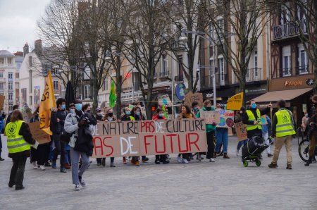 Foto de Reims, Francia - Marzo 2021 - Jóvenes activistas con banderas y letreros bloquean las vías del tranvía en Rue de Vesle, durante una manifestación de estudiantes contra el cambio climático y el calentamiento global - Imagen libre de derechos