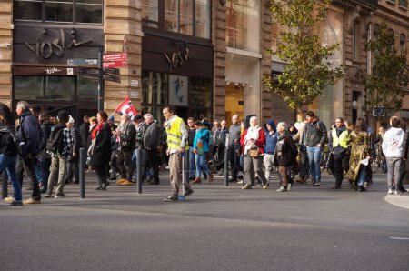 Photo for Toulouse, France - Feb. 2020 - Procession of Yellow Vest (Gilets jaunes) demonstrators, marching against Emmanuel Macron's pension reform and social policy, with a handicapped person using crutches - Royalty Free Image