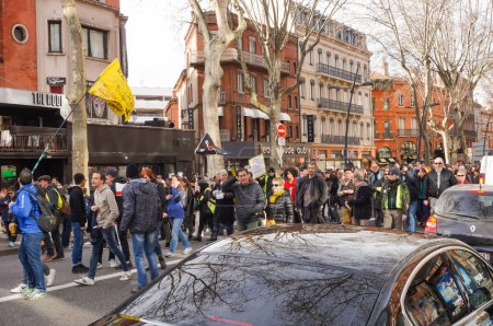 Téléchargez les photos : Toulouse, France - Février 2020 - Procession de militants d'extrême gauche et de manifestants de Gilets jaunes agitant des banderoles et s'opposant à la réforme des retraites d'Emmanuel Macron, à Strasbourg Bpulevard - en image libre de droit