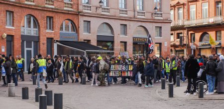Photo for Place Wilson, Toulouse, France - Feb. 2020 - Far-left anarchists, unionists and Yellow Vest with a "Gilets jaunes ! We continue" banner and a skull flag, protesting against E. Macron's social policies - Royalty Free Image