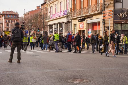 Téléchargez les photos : Toulouse, France - Février 2020 - Un journaliste indépendant équipé d'une caméra vidéo sur une tige et d'un microphone filmant un défilé de Gilets jaunes (Gilets jaunes) protestant contre la réforme des retraites - en image libre de droit