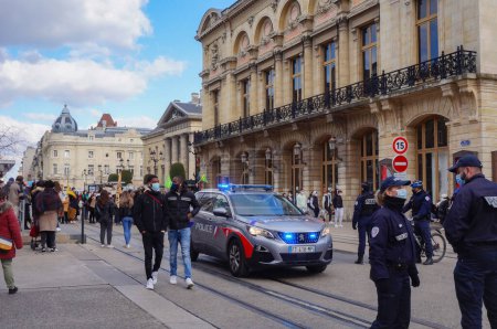 Téléchargez les photos : Reims, France - Mars 2021 - Des policiers à pied, à vélo ou en voiture, avec un nouveau véhicule Peugeot 5008, sécurisant une démonstration d "étudiants qui bloquent les voies de tramway sur la rue de Vesle - en image libre de droit