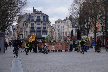 Téléchargez les photos : Reims, France - Mars 2021 - De jeunes militants avec des drapeaux et des panneaux bloquent les voies de tramway de la rue de Vesle, lors d'une manifestation d "étudiants contre le changement climatique et le réchauffement climatique - en image libre de droit
